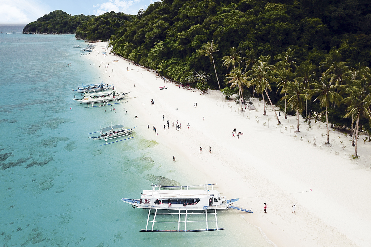 Boats sit along the white sand beach of Boracay. | EMBASSY OF THE PHILIPPINES
