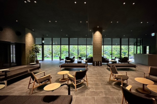 The furniture, made locally in Kyushu, and colors of Unzen Miyazaki Ryokan's lobby are neutral to allow guests to better enjoy the beautiful views of the Japanese garden and the mountains beyond.